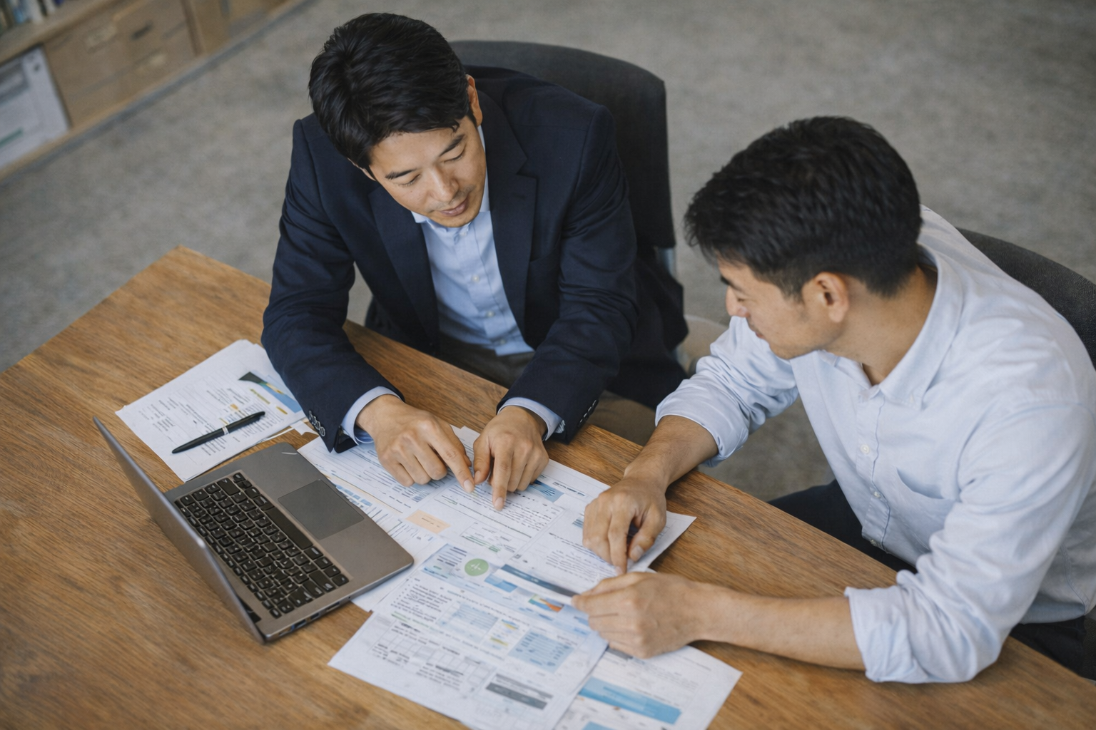 日本人ビジネスマンが資料を見ながらコンサルティングする様子